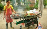 泰国街头小贩准备木炭烧烤传统香肠