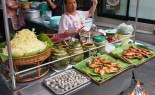 泰国街头小贩提供新鲜的Som Tum木瓜沙拉，鸡阳烤鸡，和蛤