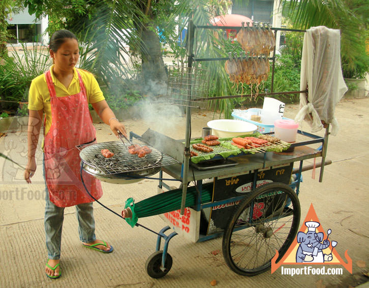 泰国街头供应商准备木炭烤肉传统香肠